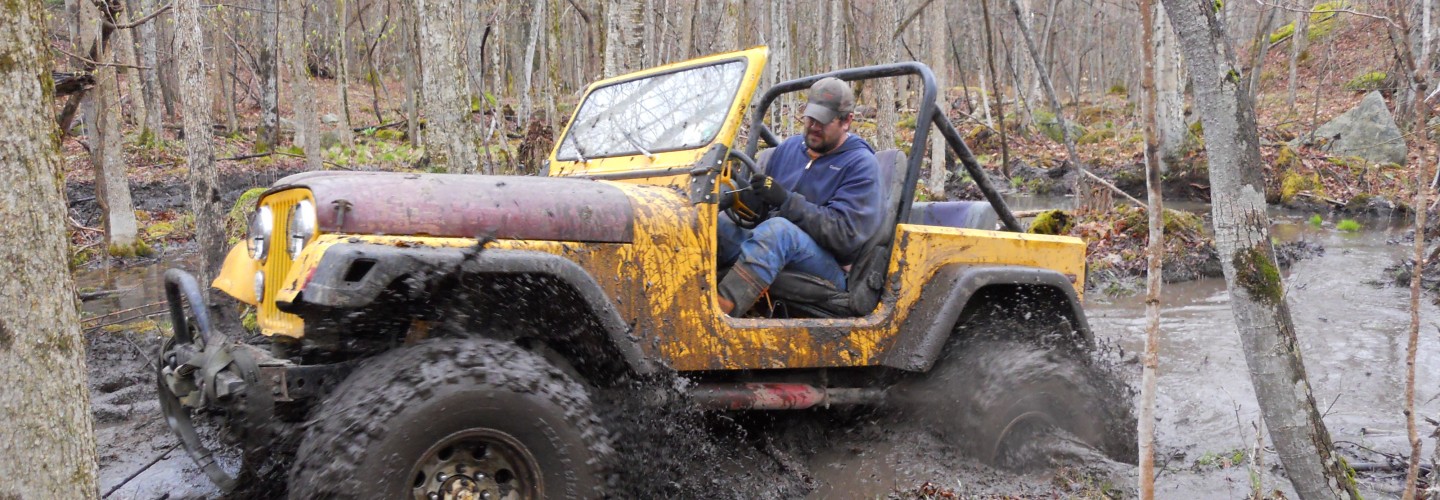 Joe Chase in Yellow Jeep CJ 7 with boggers in mud